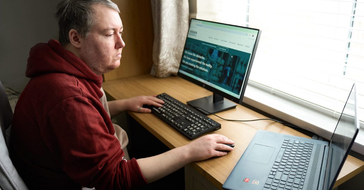 Vision for access founder Mark sitting at a desktop computer